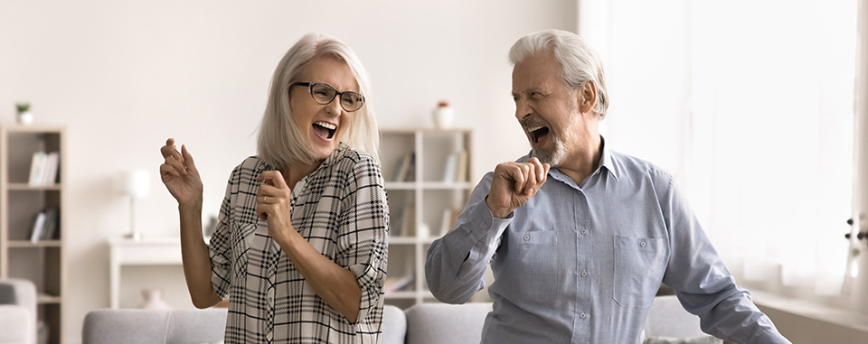 Een ouder echtpaar danst vrolijk in de kamer